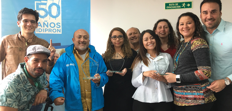 Director Wilfredo Grajales con equipo bici sosteniendo tres premios